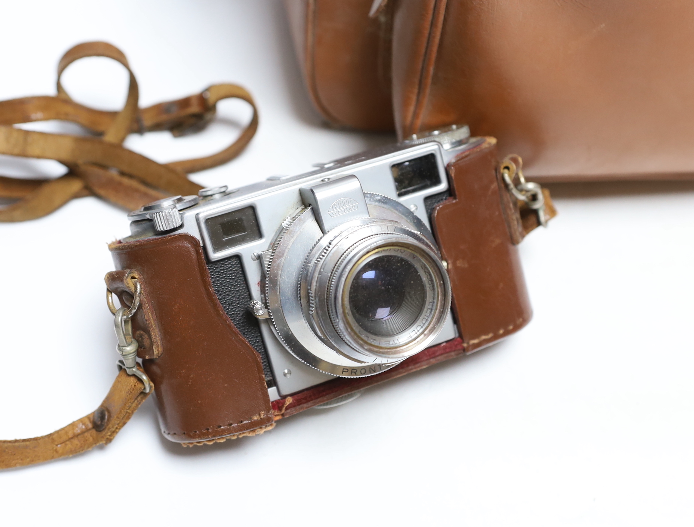 A Lordomat leather cased camera, lenses, flashgun, tripod and larger camera case